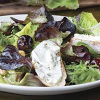 Garden lettuce salad with roasted cherries, fromage blanc and hazelnuts